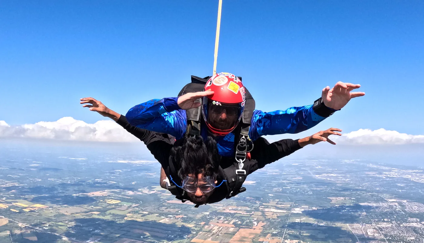 Tandem skydivers in freefall over the landscape